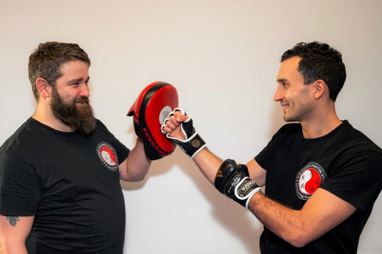 Das Bild zeigt zwei Personen, die das Ving Tsun Pratzentraining üben. Es ist zu sehen, dass beide Personen viel Spass beim Training haben. 